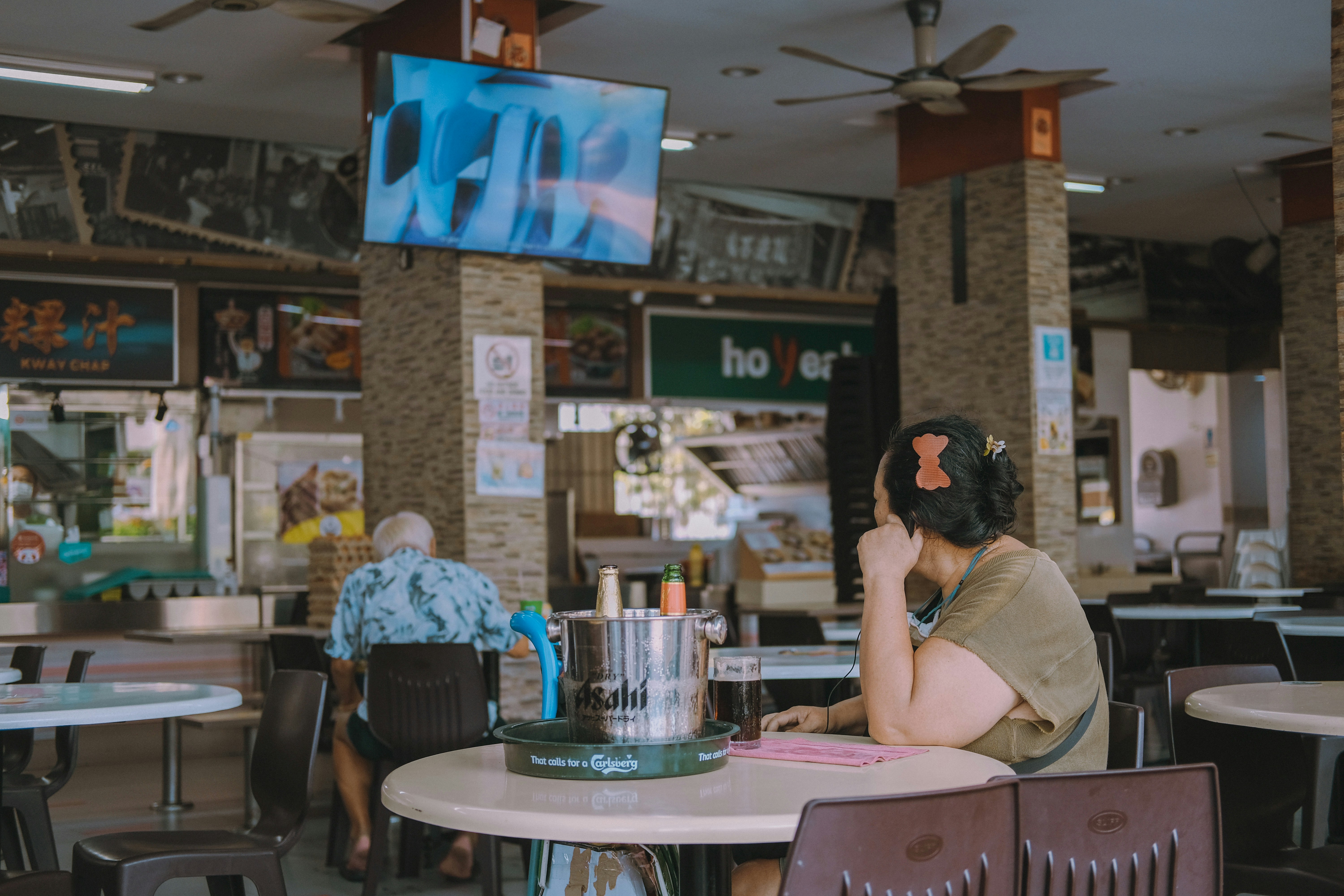 Took this when i was resting at a coffee shop nearby in the afternoon and saw this lady just watching the TV, minding her own business.